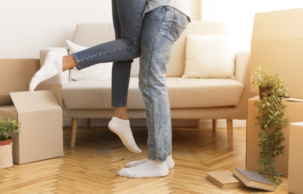 Unrecognizable Husband Lifting Wife Among Moving Boxes In New House - Foto, immagini