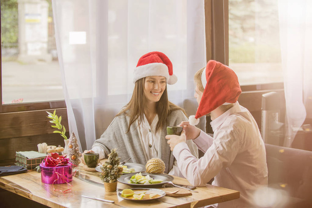 mec et fille couple célébrer Noël dans café habillé en chapeaux de Noël
 - Photo, image