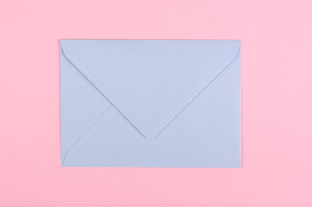 Blue paper envelope composition on pink background. - Фото, зображення