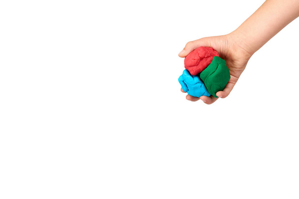 Детская рука с цветным пластилином, детская образовательная игрушка
. - Фото, изображение