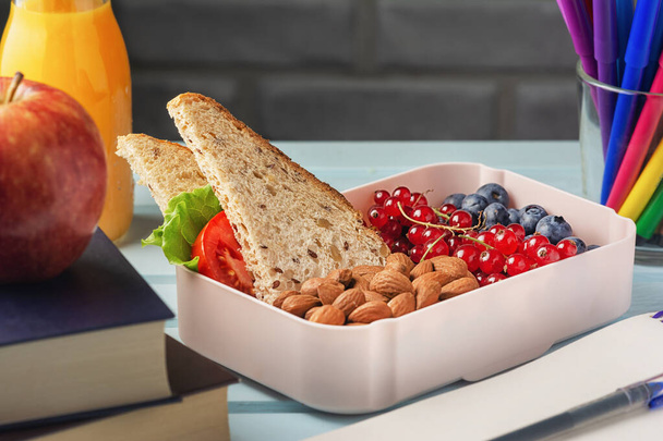 Nützlicher Imbiss für Schüler und Studenten. Lunchbox mit Beeren, Nüssen und einem Sandwich - Foto, Bild