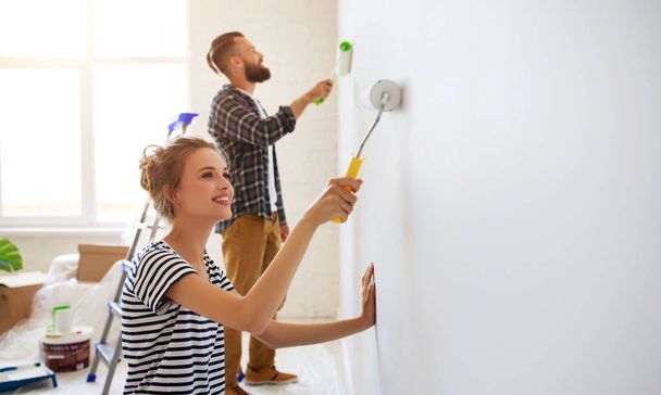 young happy couple is repairing and painting   wall at home - Foto, imagen
