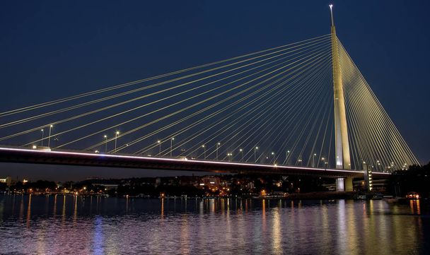 Belgrad, Sırbistan - Geceleri Sava Nehri 'ni kaplayan Ada Köprüsü manzarası - Fotoğraf, Görsel