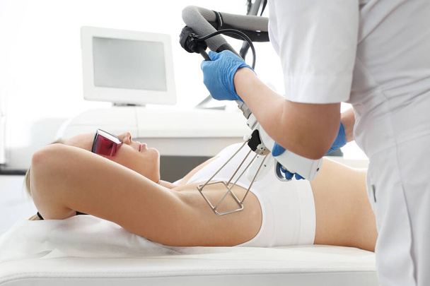 Лазерная эпиляция. Женщина в косметической клинике во время лазерной эпиляции подмышек
 - Фото, изображение