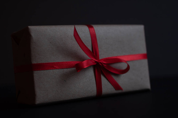 Geschenkbox mit Schleifenknoten auf dunklem Hintergrund - Foto, Bild