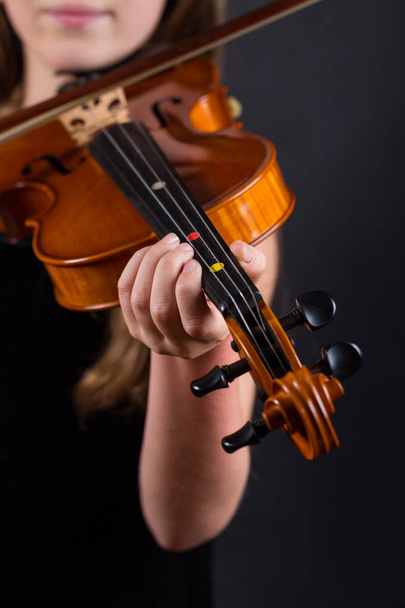 Close up of professional violin in hands of little violinist playing it - Foto, afbeelding