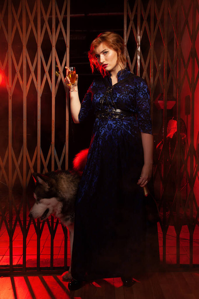 nő egy pohár pezsgővel a kezében, és egy alkoholos üveg áll a legjobb barátja egy nagy kutya, és szomorú egyedül - Fotó, kép