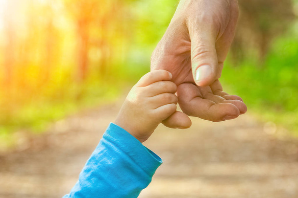 the parent holding the child's hand with a happy background - Foto, imagen