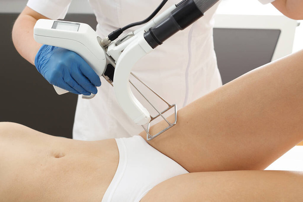 Laser hair removal. A woman in a cosmetic clinic during a laser hair removal procedure in the bikini area - Fotó, kép