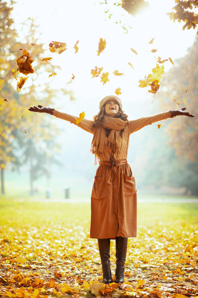 γυναίκα απολαμβάνει το φθινόπωρο και να πιάσει πεσμένα κίτρινα φύλλα - Φωτογραφία, εικόνα