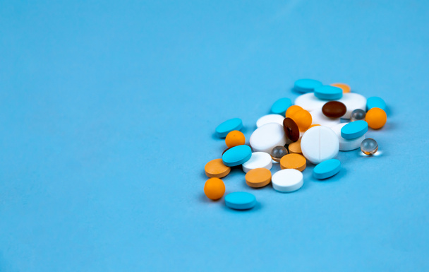 Multi-gekleurde pillen op een blauwe achtergrond close-up, met kopie spa - Foto, afbeelding
