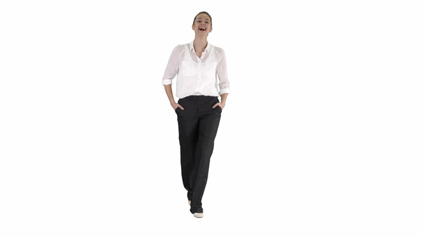 Donna d'affari che cammina con le mani in tasca e ride su sfondo bianco. - Filmati, video