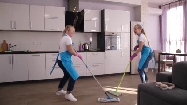 Vidám takarítók énekelnek és táncolnak felmosás közben - Felvétel, videó