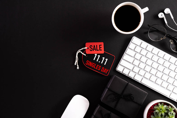 Online shopping of China, 11.11 singles day sale concept. Red paper tag with keyboard mouse coffee cup, gift box and earphone on black background with copy space for text 11.11 singles day sale. - Foto, Imagem