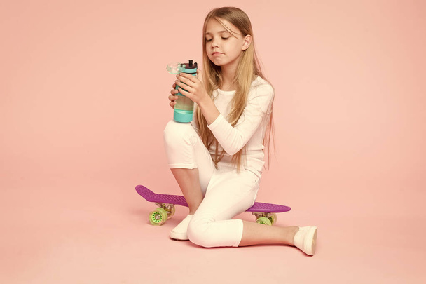 Girl having fun with penny board pink background. Kid adorable child long hair adore ride penny board. Ride penny board and do tricks. Girl likes to ride skateboard. Active lifestyle. Trendy girl - Zdjęcie, obraz