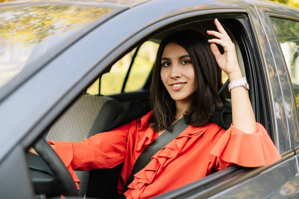 Modern woman sitting in car and smiling - Fotó, kép