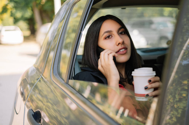 Female manager using mobile while sitting in car - Valokuva, kuva