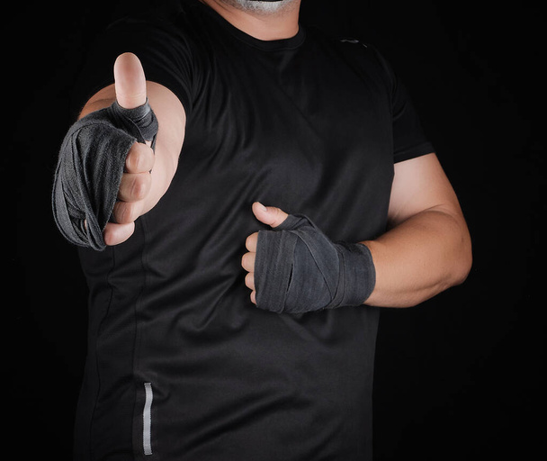 руки спортсмена, завернутые в черную эластичную спортивную повязку
 - Фото, изображение