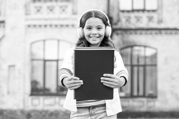 An awesome way of learning a language. Little girl learning English language with audio book. Happy small child listening to audio language course. Learn to speak a foreign language with confidence - Foto, immagini