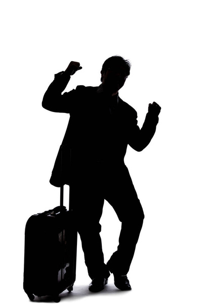 Silhouette of a backlit model posing as a businessman on a white background.  He is gesturing like he is happy or winning - Foto, Imagen
