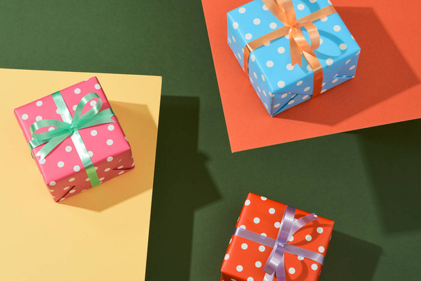 Karácsonyi ajándékdobozok szalagokkal a színes asztalra - Fotó, kép