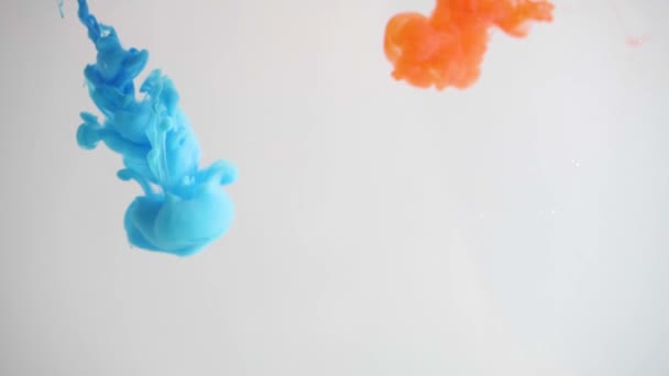 Diffusion of orange and blue paint in water. Abstract colourful smoke explosion. Mixing bright colors, ink of blue color mixed with orange in slow motion of water. Beautiful color dilution - Кадры, видео