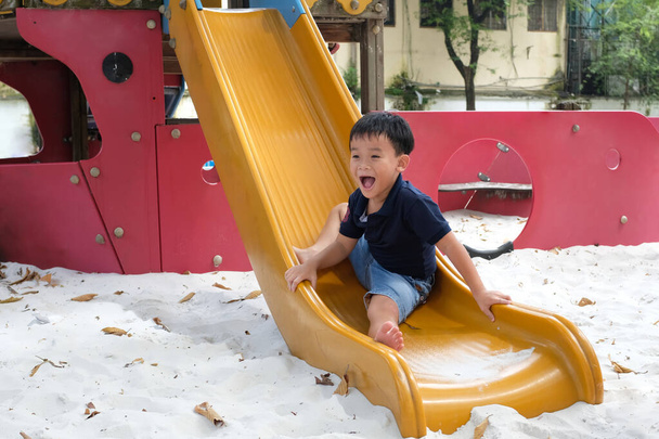 Kind spielt auf Spielplatz im Freien. Kinder spielen auf dem Schul- oder Kindergartenhof.  - Foto, Bild