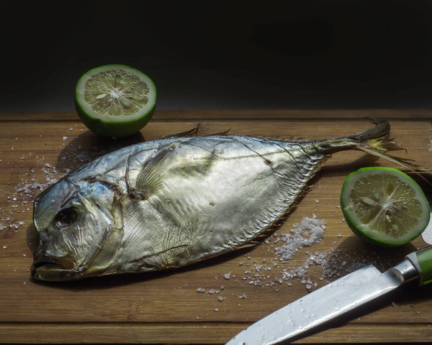 Риба-вомер копчена і нарізана лаймом крупним планом на кухонній дошці
 - Фото, зображення
