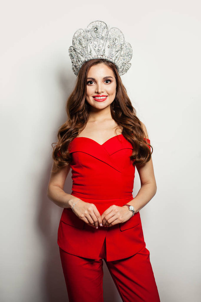 Pretty woman wearing red suit and diamond crown. Smiling model  - Φωτογραφία, εικόνα