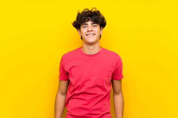 Nuori mies yli eristetty keltainen seinä nauraa
 - Valokuva, kuva