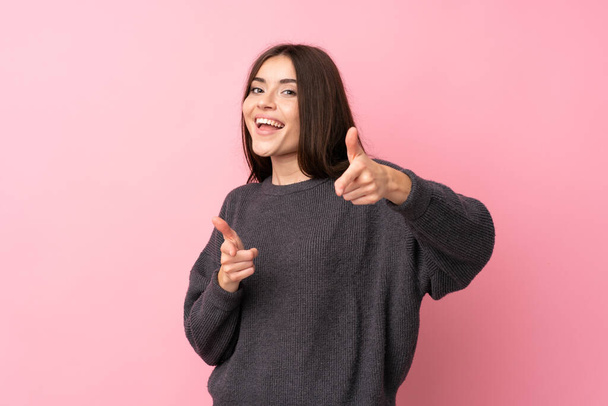 Young woman over isolated pink background pointing to the front and smiling - Fotó, kép