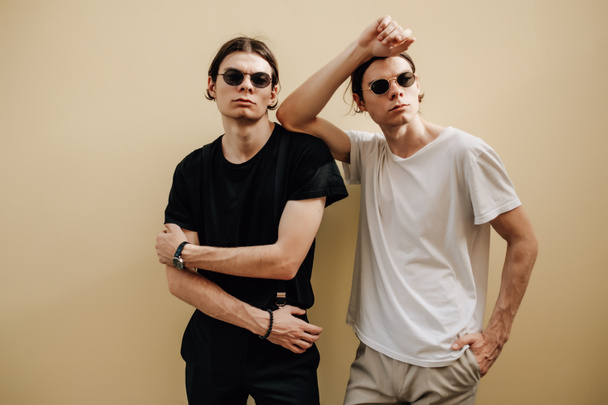 Fermer Portrait de deux frères jumeaux élégants vêtus de T-shirts noirs et blancs
 - Photo, image