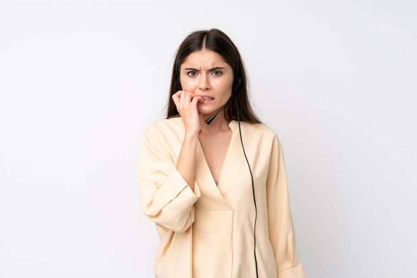 Young telemarketer woman over isolated white background nervous and scared - Photo, Image