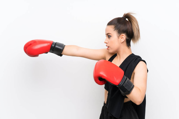 Молодая спортсменка на белой стене в боксёрских перчатках
 - Фото, изображение
