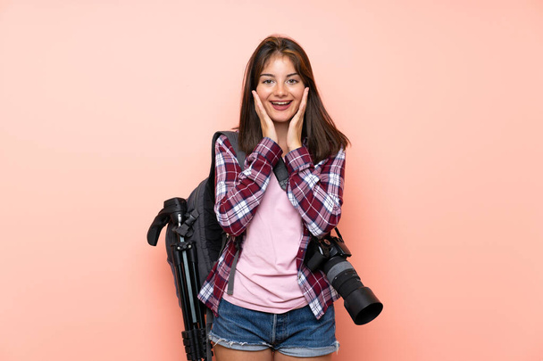 Jovem fotógrafa menina sobre fundo rosa isolado com expressão facial surpresa
 - Foto, Imagem