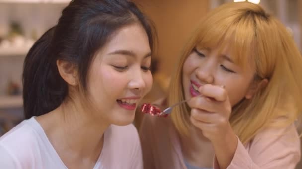 Cheerful young Asian lesbian couple eating food and cake at coffee shop. Two joyful attractive Asia lady together at restaurant or cafe. LGBT or LGBTQ, Holiday activity, or modern lifestyle concept. - Πλάνα, βίντεο