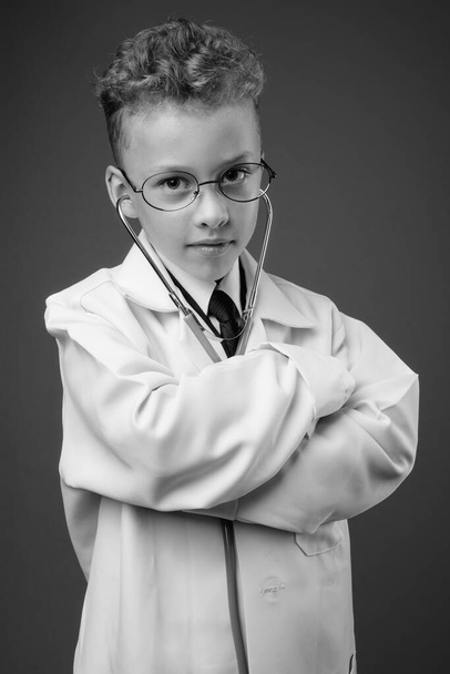 Студийный снимок мальчика в черно-белом образе врача
 - Фото, изображение