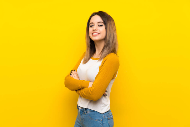 Красива молода жінка над ізольованою жовтою стіною з схрещеними руками і з нетерпінням чекає
 - Фото, зображення