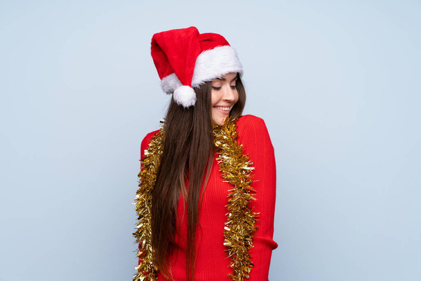 Girl with christmas hat over isolated blue background - Фото, изображение
