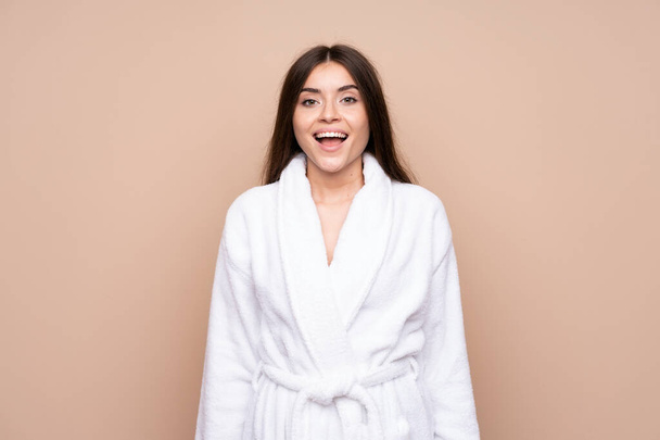 Young girl in a bathrobe over isolated background with surprise facial expression - Foto, Bild