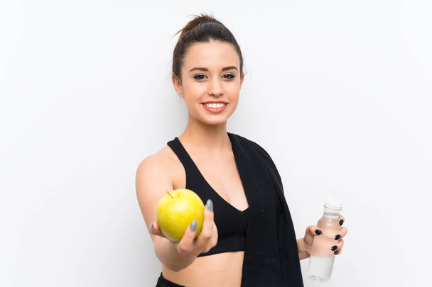 Jonge Sportvrouw over witte muur met een appel - Foto, afbeelding