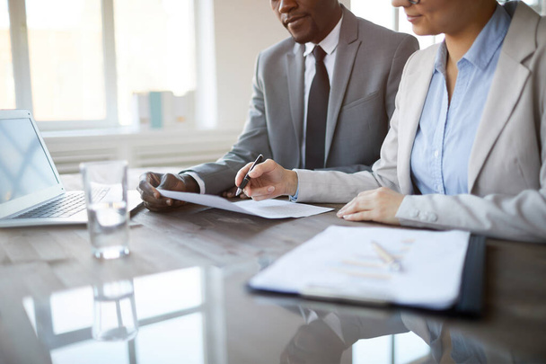 Обрезанный образ неузнаваемых деловых людей, подписывающих контракт во время встречи в офисе, акцент на женской ручке, копировальном пространстве
 - Фото, изображение