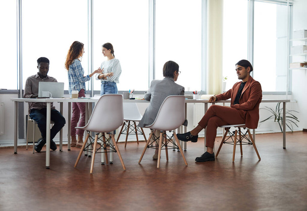 オフィスの会議テーブルに座って近代的なオフィスで働く現代のビジネスチームでの広い視野、コピースペース - 写真・画像