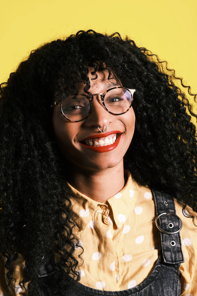 jovem afro-americano com penteado afro, óculos e fundo amarelo
 - Foto, Imagem