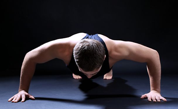 Handsome young muscular sportsman, on dark background - Fotografie, Obrázek