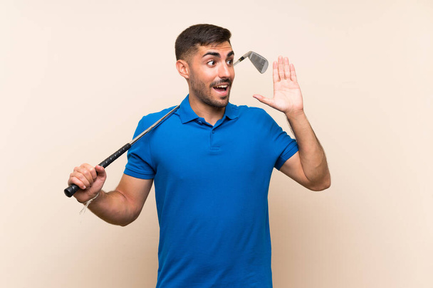Νεαρός όμορφος παίκτης του γκολφ πάνω από απομονωμένο φόντο φωνάζοντας με το στόμα ορθάνοιχτο - Φωτογραφία, εικόνα