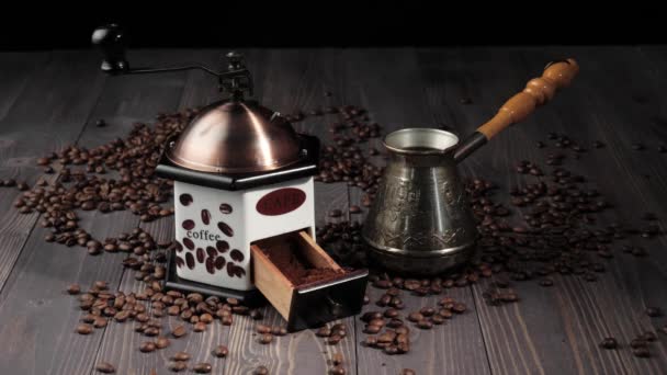 コーヒー豆から構成されます。香り高いコーヒー豆で飾られた木製のテーブルの背景。手は木製のテーブルからコーヒーメーカーを取ります。4k - 映像、動画