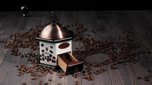 Samenstelling uit koffiebonen. Houten tafel achtergrond versierd met geurige koffiebonen. Hand zet het koffiezetapparaat in houten tafel. 4k - Video