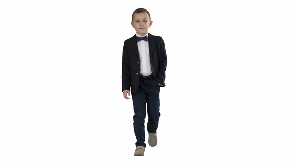 Chłopiec w stroju formalnym chodzenie z ręką w kieszeni na białym tle. - Materiał filmowy, wideo