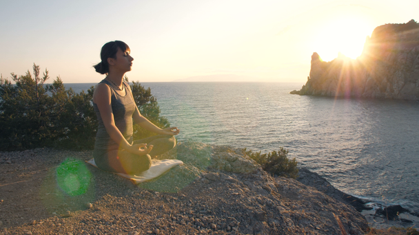 Kobieta medytuje nad morzem - Materiał filmowy, wideo